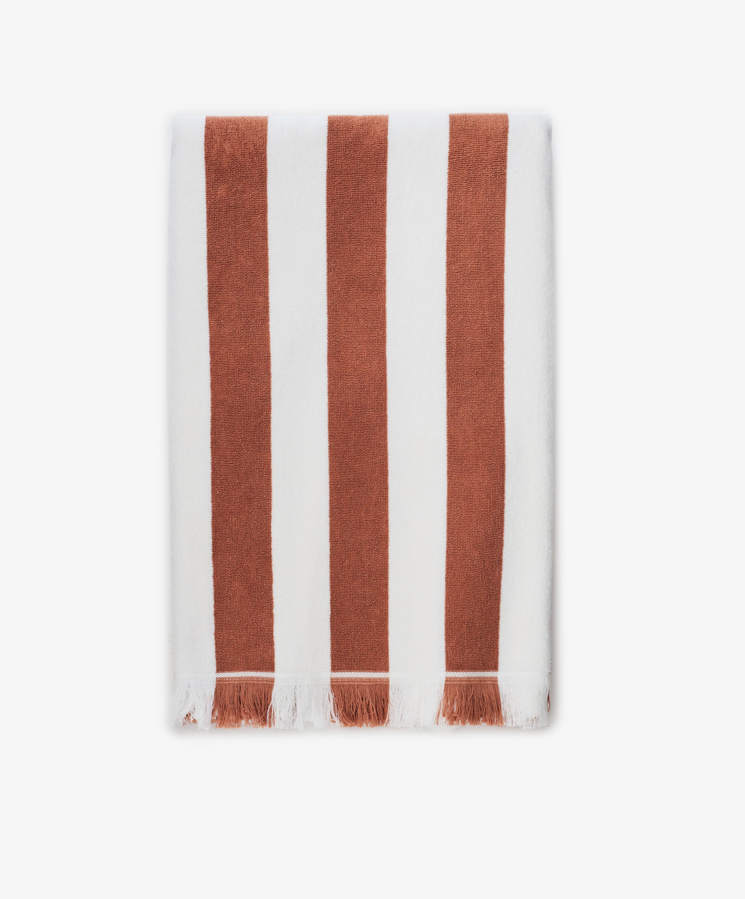 The Paloma Stripe Towel, crafted from striped cotton in bold brown and white verticals with a short white fringe along the bottom edge, evokes the relaxed elegance of the Italian coast.