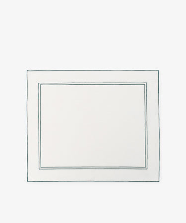 The Flavia Placemat, Set of 6, features rectangular white linen with two thin dark-bordered outlines near the edges—a refined and durable choice for elegant table settings.