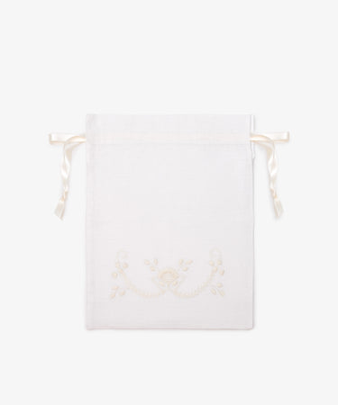 The Linen Drawstring Bag is handmade in Portugal from white linen, with cream Viana do Castelo embroidery and ribbon ties. Shown flat on a plain light background.