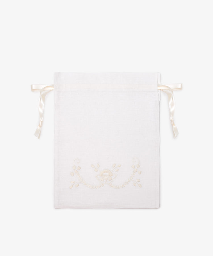 The Linen Drawstring Bag is handmade in Portugal from white linen, with cream Viana do Castelo embroidery and ribbon ties. Shown flat on a plain light background.