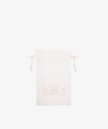 The Linen Drawstring Bag, handmade in Portugal from light-colored linen, features subtle Viana do Castelo embroidery on the front and is shown against a plain white background.