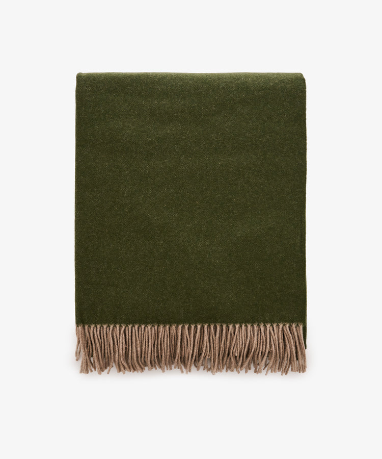 A folded Ulisse Throw in forest green with beige fringe along the bottom edge, displayed on a white background.