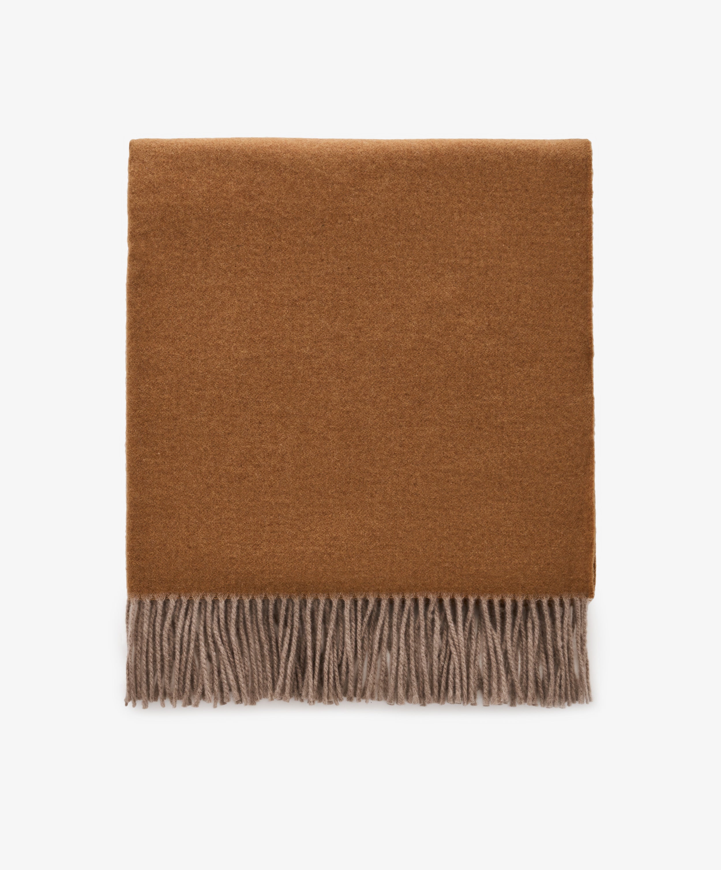 The Ulisse Throw, a folded brown wool piece with beige fringe detailing, is displayed on a plain white background.