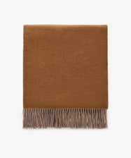 The Ulisse Throw, a folded brown wool piece with beige fringe detailing, is displayed on a plain white background.