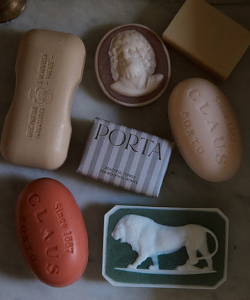 Hercules Soap offers decorative and sculptural bars in oval, rectangular, and unique shapes, beautifully arranged on a marble surface.