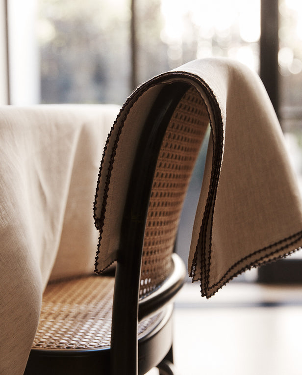 Chair with a beige blanket draped over it, blurred background