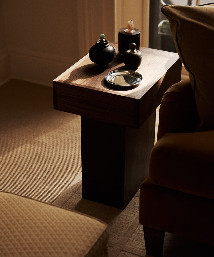 wood side table with wood boxes on it and a silver dish