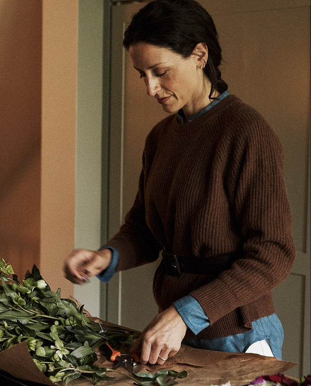 Woman arranging flowers in a kitchen