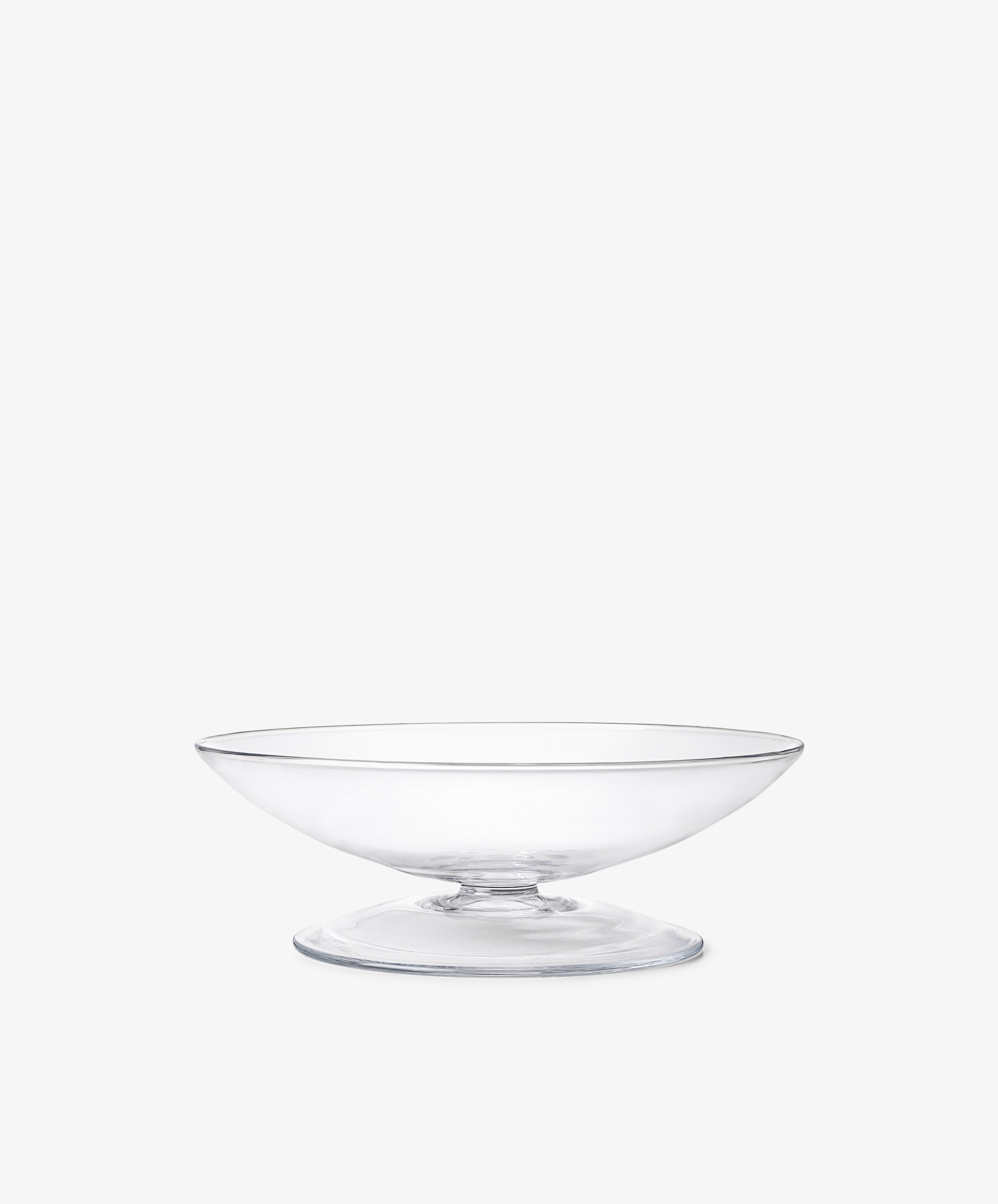 The Bubble Glass Grape Tray features a clear, wide, shallow pedestal design that highlights exquisite glass-blowing artistry, resembling a sculptural tray, and is shown against a plain white background.