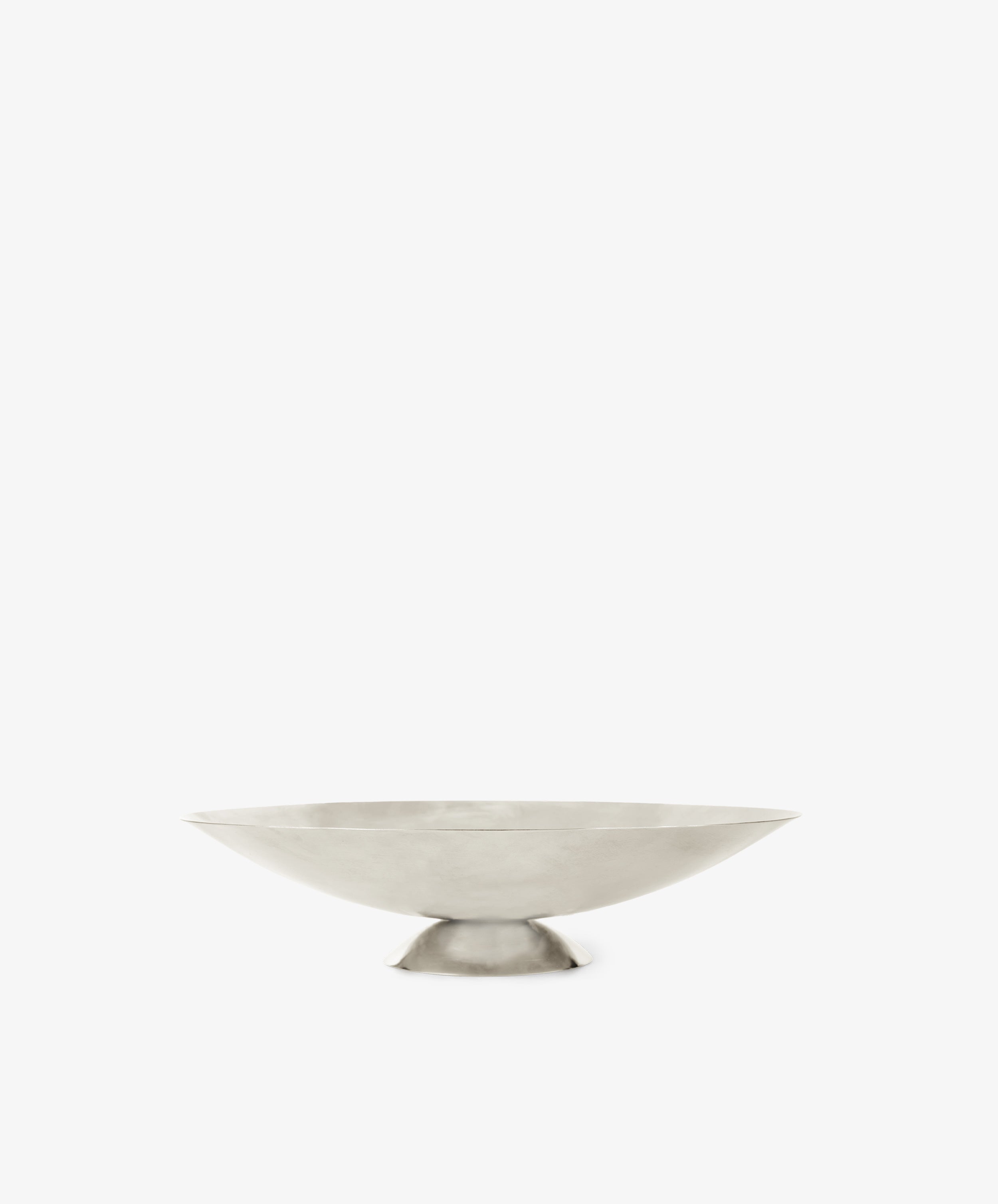 The Metal Grape Tray is a minimalist, shallow polished steel tray featuring a wide rim and small circular base, shown on a plain white background.