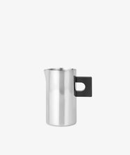 The S.R. Metal Pitcher features a sleek stainless steel body with a bold black rectangular handle, offering a modern, sculptural look against a plain white backdrop.