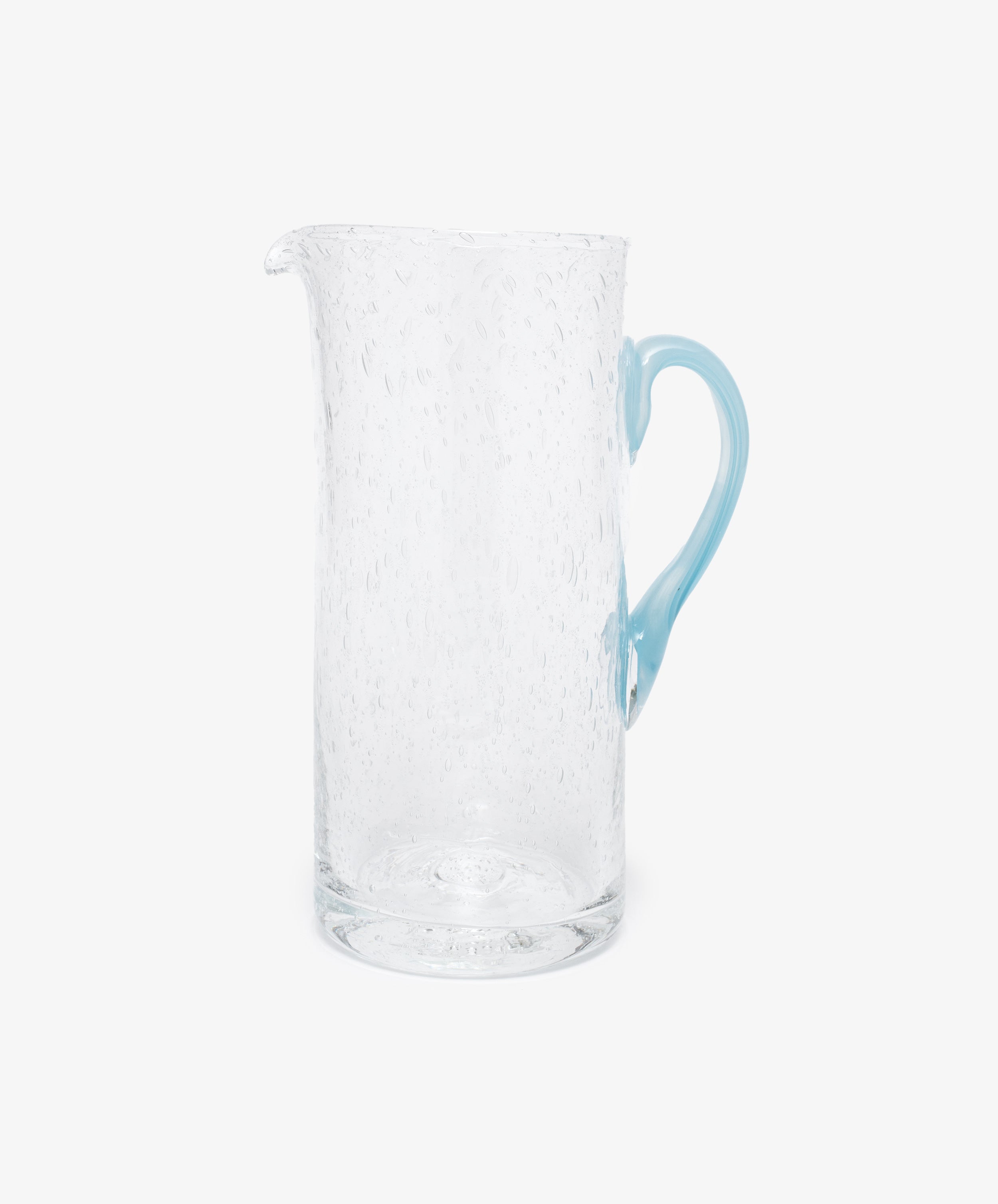 Pauline Jug by La Romaine Editions. Hand-blown clear glass pitcher with light blue handle.