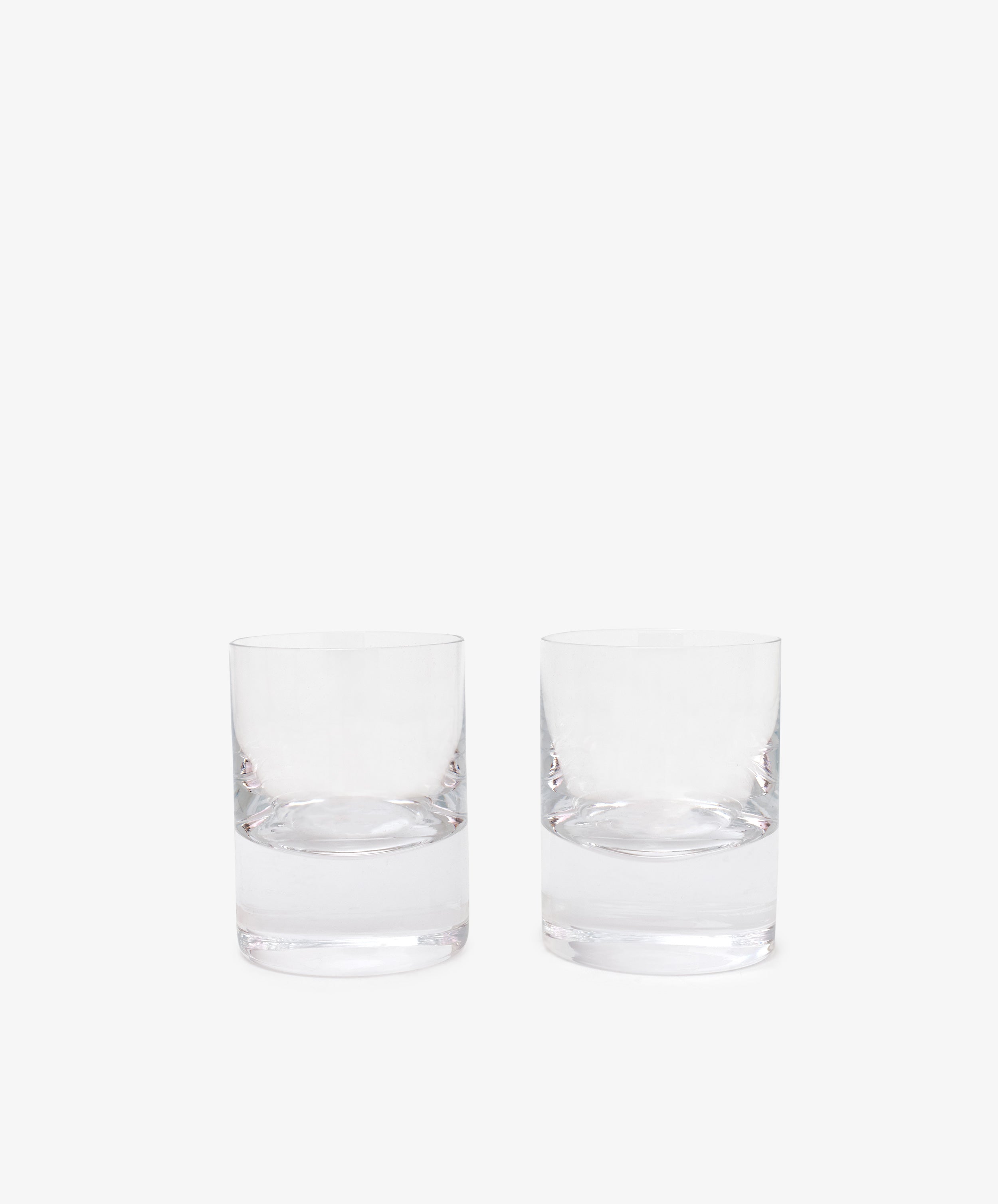 The Boris Tumbler, Set of 2, features clear, empty whisky glasses with weighted bases placed side by side against a plain white background.