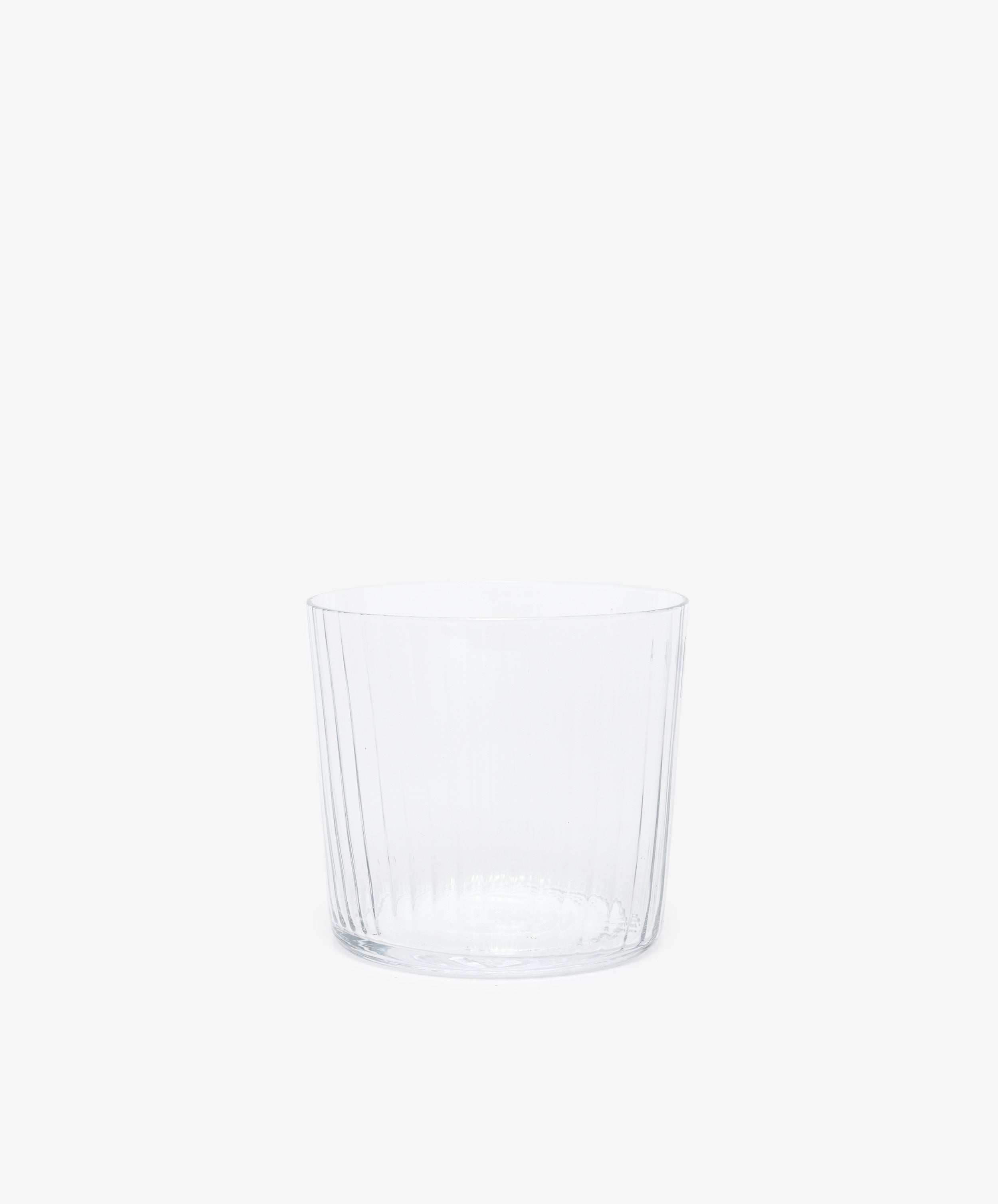 Single clear ribbed tumbler glass.