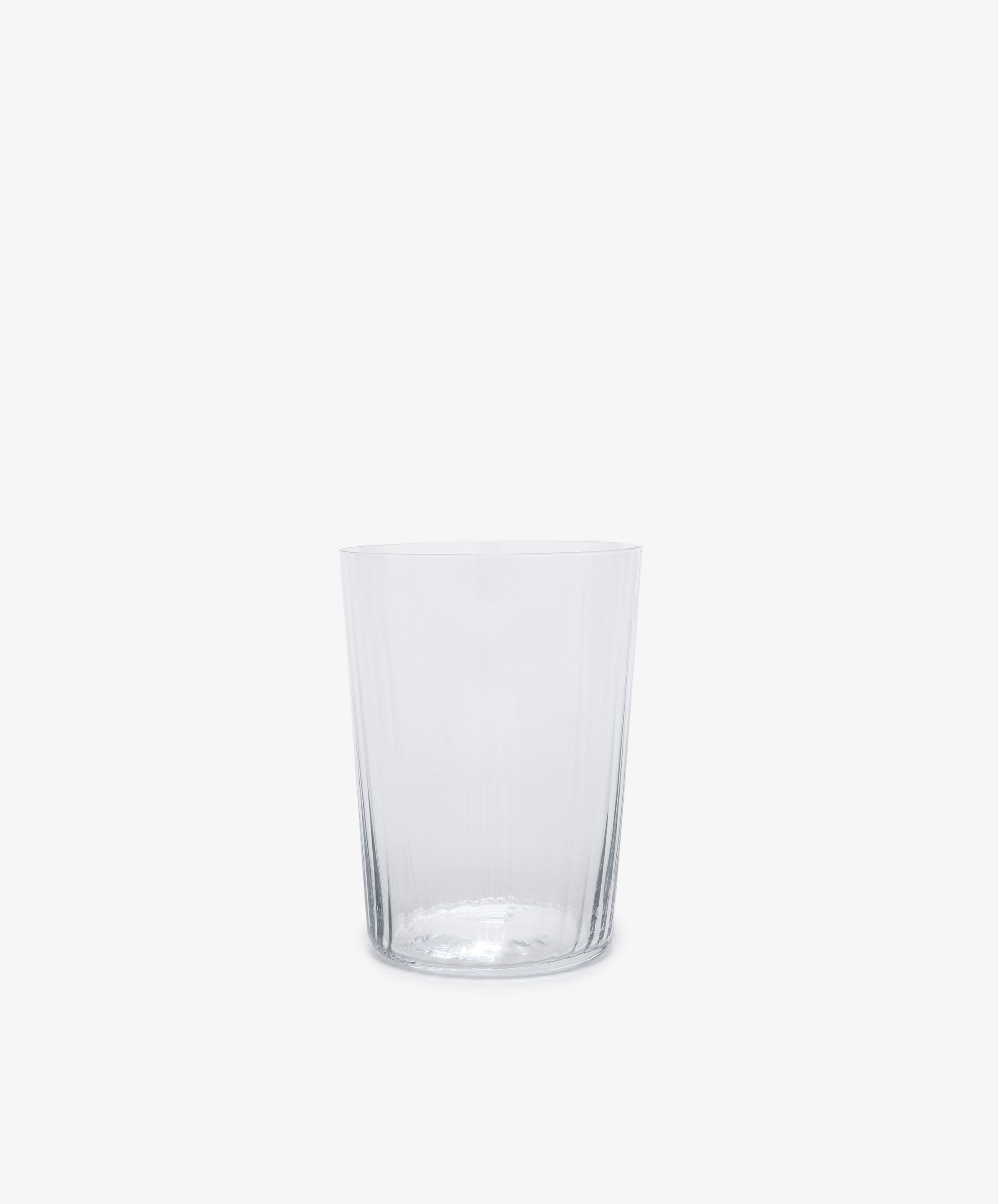 Single clear tall ribbed tumbler glass.