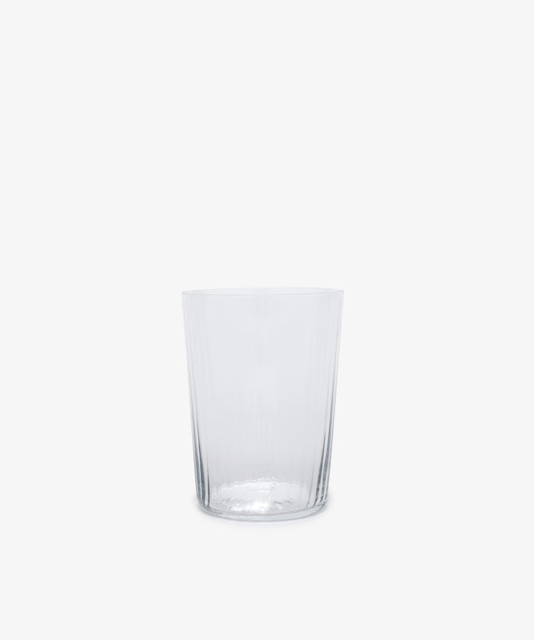 Single clear tall ribbed tumbler glass.