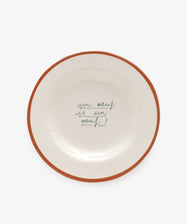 Un Oeuf is un Oeuf by Laetitia Rouget. White stoneware plate with red painted rim and cursive writing.