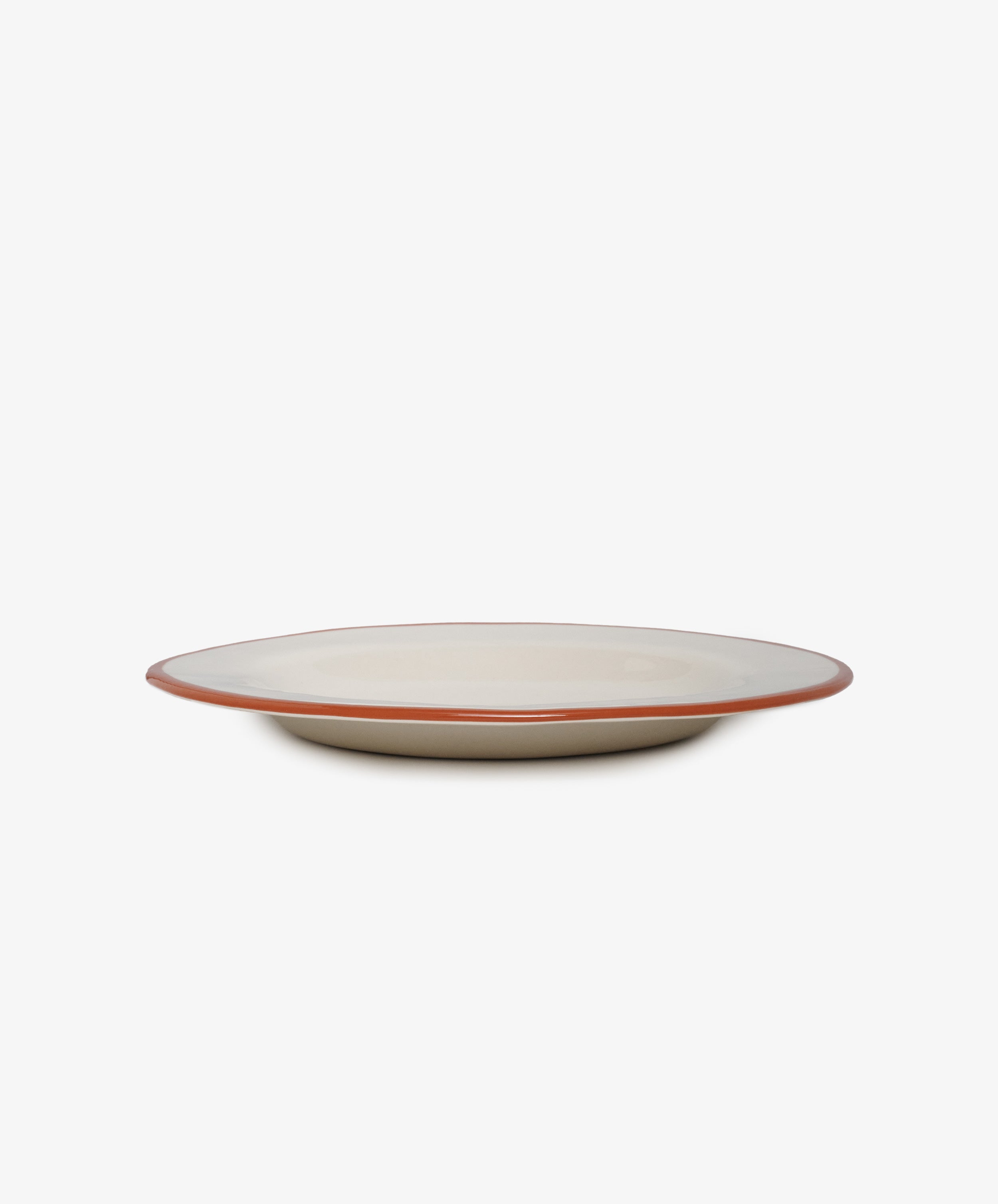 Un Oeuf is un Oeuf  white stoneware plate with red painted rim, side view.