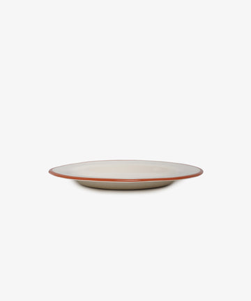 The Un oeuf is un oeuf plate is a round, off-white ceramic dish with a slim brown rim, showcased on a white background—an elegant stoneware piece.