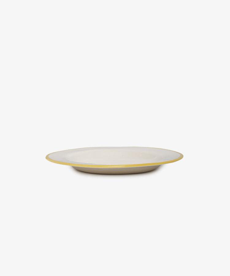 The Honey, youre the bees knees plate is a shallow, round handmade ceramic piece with a white surface and a thin yellow rim, inspired by Laetitia Rouget’s charm, shown against a plain white background.