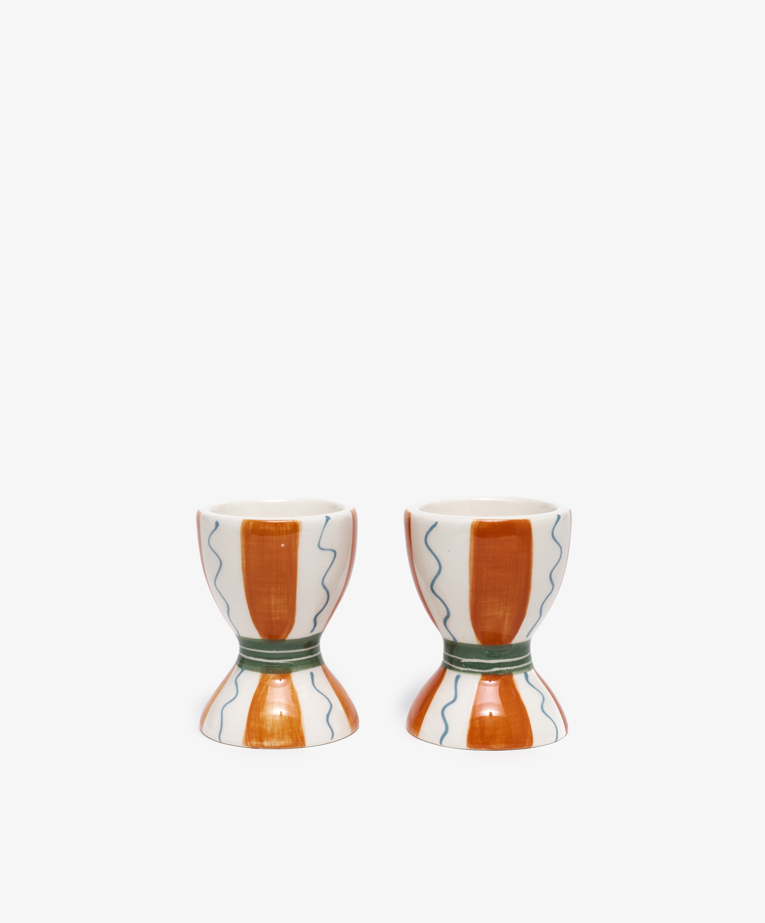 Wiggle Oeuf! Egg Cup by Laetitia Rouget. Pair of stoneware cups with painted orange stripe and blue squiggles.