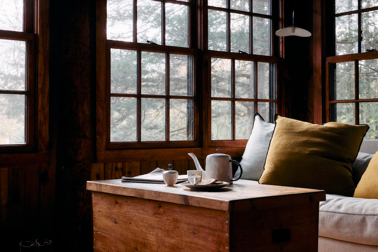sofa with pillows and tea pot on wood table in cabin