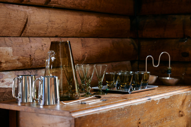 silver cups and glasses and jug on wood table
