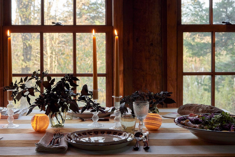 lit candles with plates on table in cabin