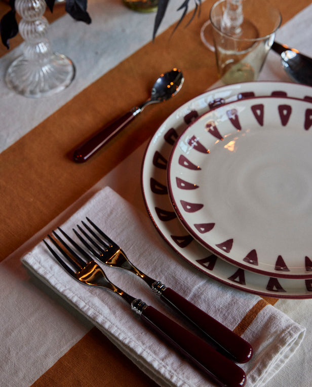 napkin and forks plates on tablecloth