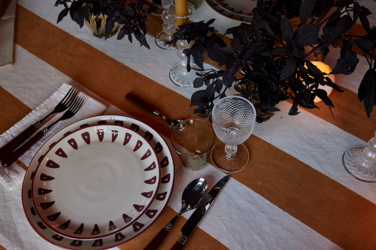 plate and glassware on table with stripe tablecloth
