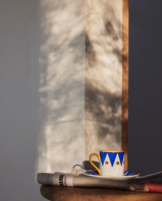 saucer and cup with newspaper on stool