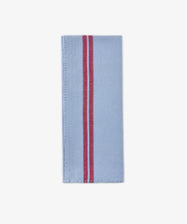 The Métis Tea Towel, crafted from light blue linen and featuring two parallel red stripes running vertically near the right edge, is displayed on a white background—a timeless piece inspired by classic French kitchen linens.