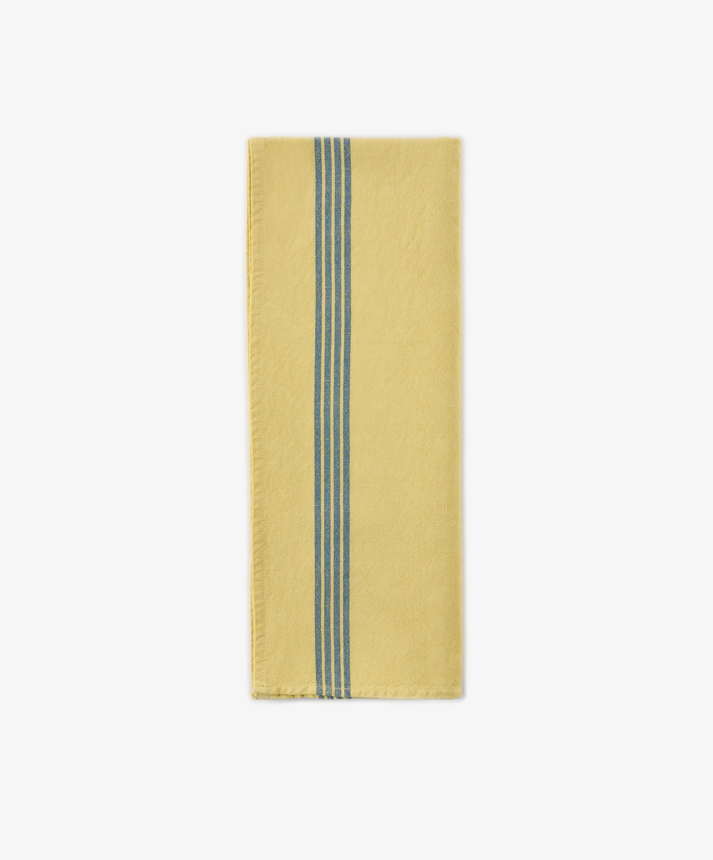 A Métis Tea Towel, folded to showcase its yellow fabric accented by two parallel blue woven stripes running vertically near one edge—a design evocative of classic French kitchen linens—is displayed on a white background.