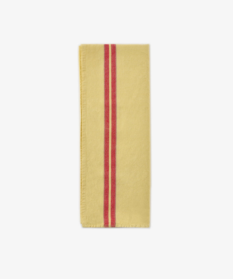 A Métis Tea Towel, featuring a folded yellow cloth with two parallel red stripes running vertically near the left edge, reminiscent of vintage tea towel designs and classic French kitchen linens, displayed on a white background.