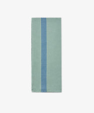 The Métis Tea Towel, a folded light green cloth featuring three vertical blue stripes near the center, is displayed on a plain white background and evokes the look of French kitchen linens and classic vintage striped tea towels.