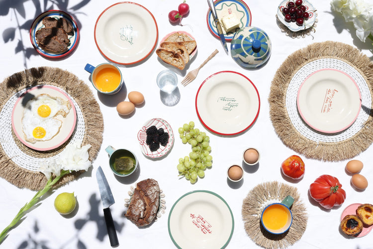 Breakfast table with plates, eggs, fruit, and bread