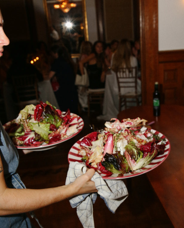 hands bringing salad dishes to the table