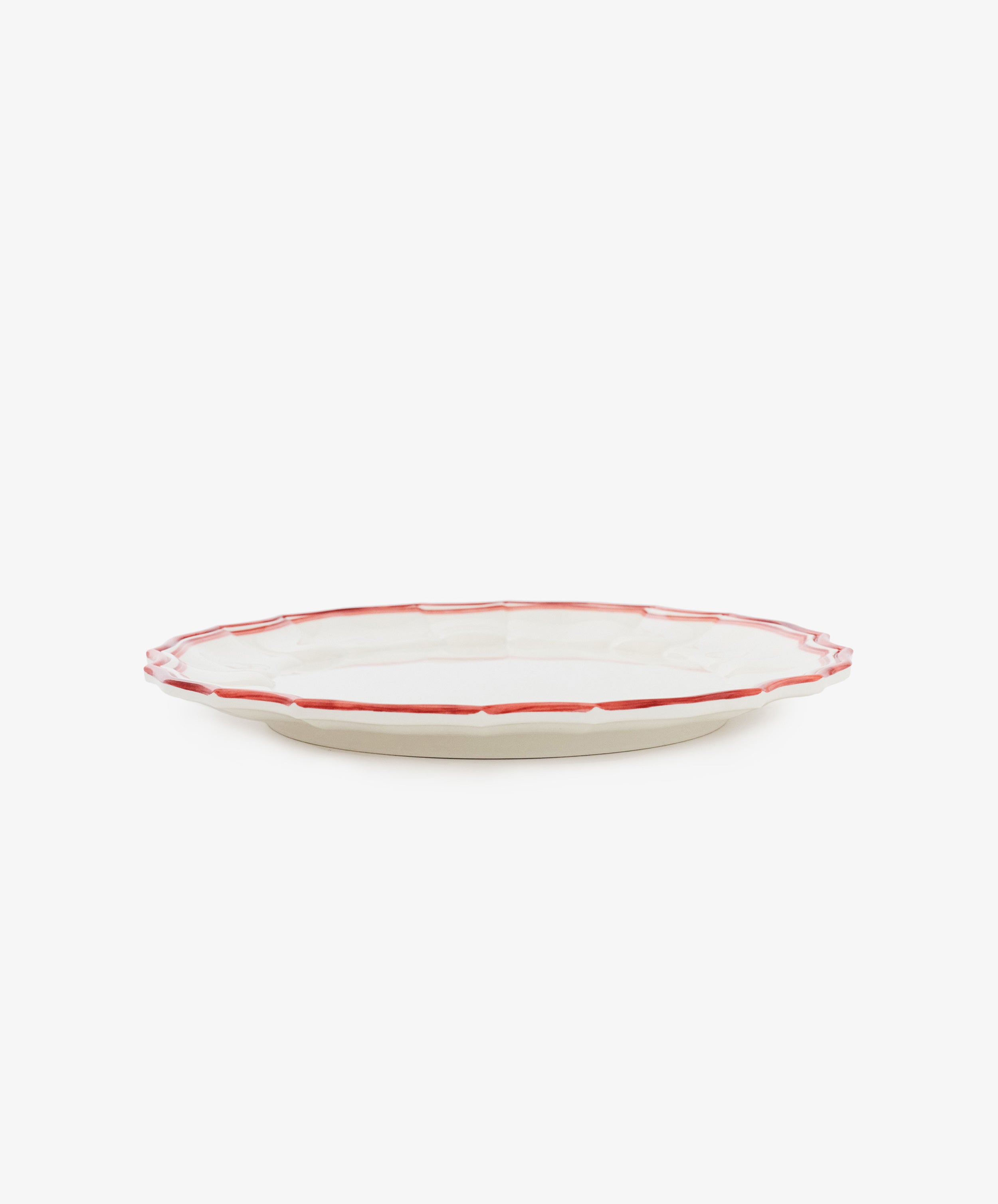 The Eva Melamine Dinner Plate, Set of 4, features a white plate with a scalloped edge and a red rim displayed on a white background, combining timeless elegance with durable dinnerware perfect for everyday use.