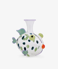 Inspired by the artistry of Murano glass, the Dotfish Decanter is a clear, fish-shaped glass vase adorned with green and blue fins, spots, a yellow eye, and an orange mouth—evoking the whimsical style found in Massimo Lunardon’s designs.