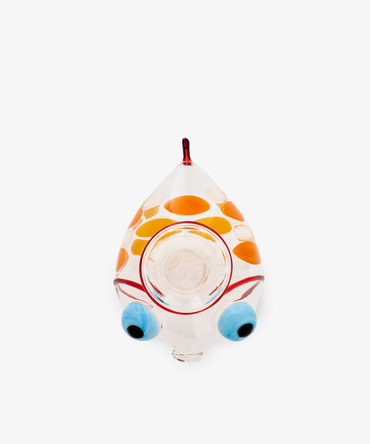 Fishpool Decanter, a Murano-style glass object shaped like a fish with orange spots, a red-tipped mouth, and large blue and black circular eyes—reminiscent of Massimo Lunardon’s signature craftsmanship—viewed from above on a plain white background.