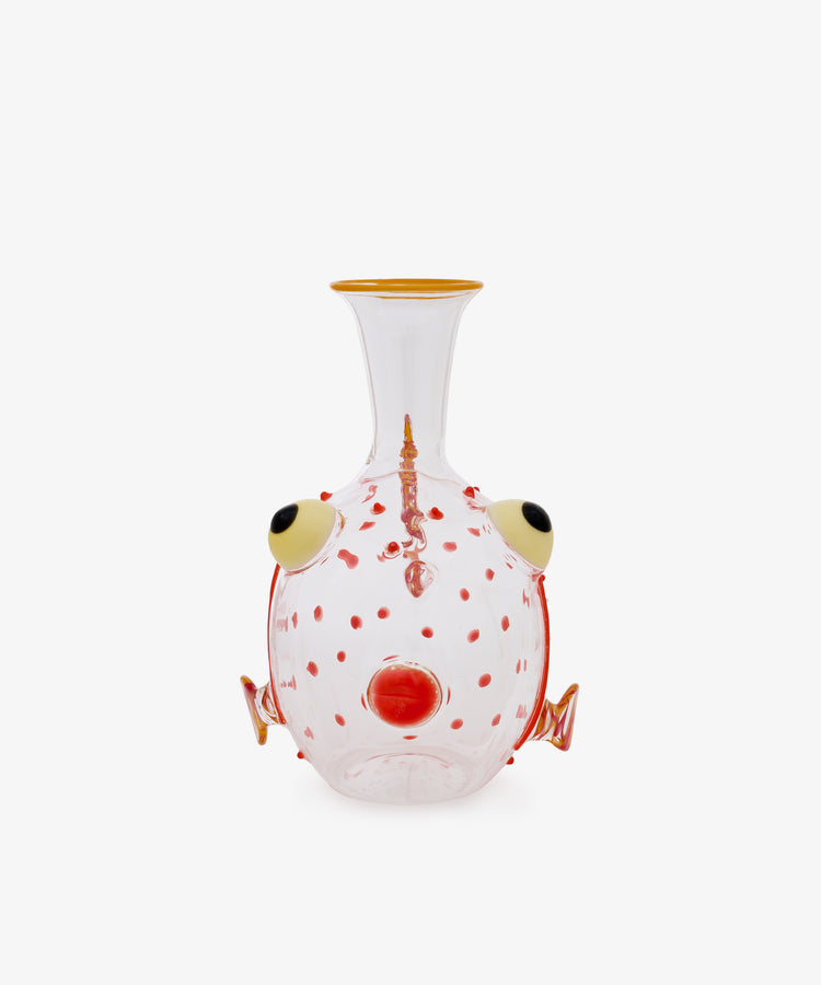 Guppy Decanter crafted from clear Murano glass features red spots, a yellow-rimmed mouth, protruding round eyes, and orange fin-like decorative elements along the sides. Set against a white background, this whimsical piece channels the playful style of Massimo Lunardon.