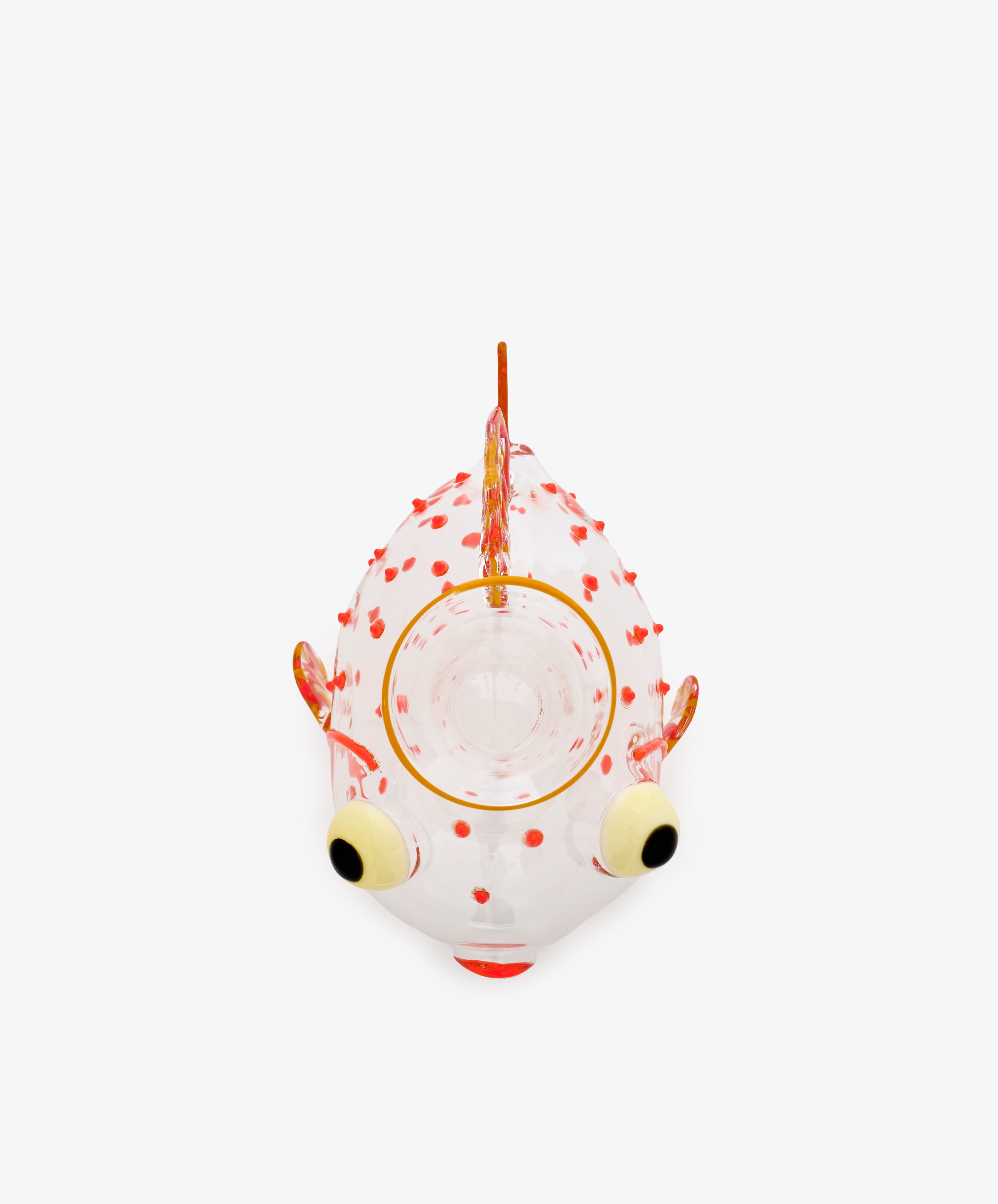 Guppy Decanter by Massimo Lunardon, a glass object shaped like a fish with orange spots, large yellow and black eyes, and an open circular mouth, photographed from above on a white background.