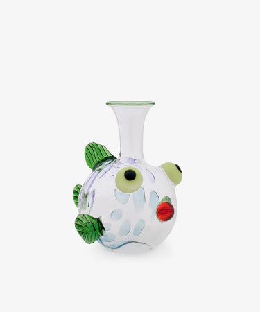 The Molly Decanter is a clear glass vase shaped like a fish, featuring green fins, large round eyes, red lips, and blue spots—evoking the artistry of Murano glass by Massimo Lunardon—presented against a plain white background.
