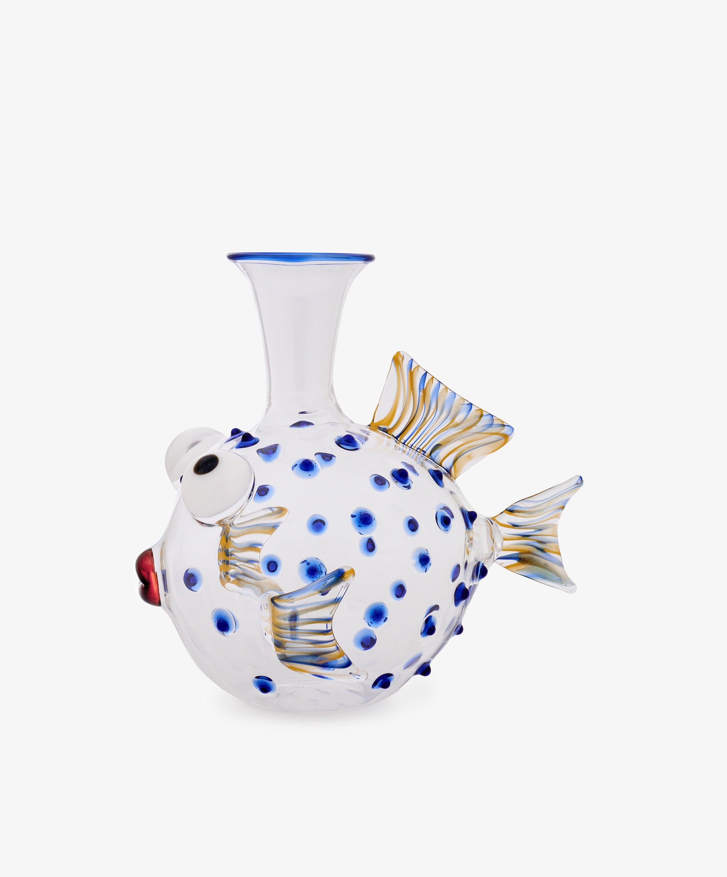 The Pappagallo Decanter features a clear glass body shaped like a fish, adorned with cobalt blue spots, striking large white eyes, and yellow-striped fins. Set against a white background, this piece draws inspiration from the playful artistry of Massimo Lunardon and evokes the refined craftsmanship of Murano glass decanters.