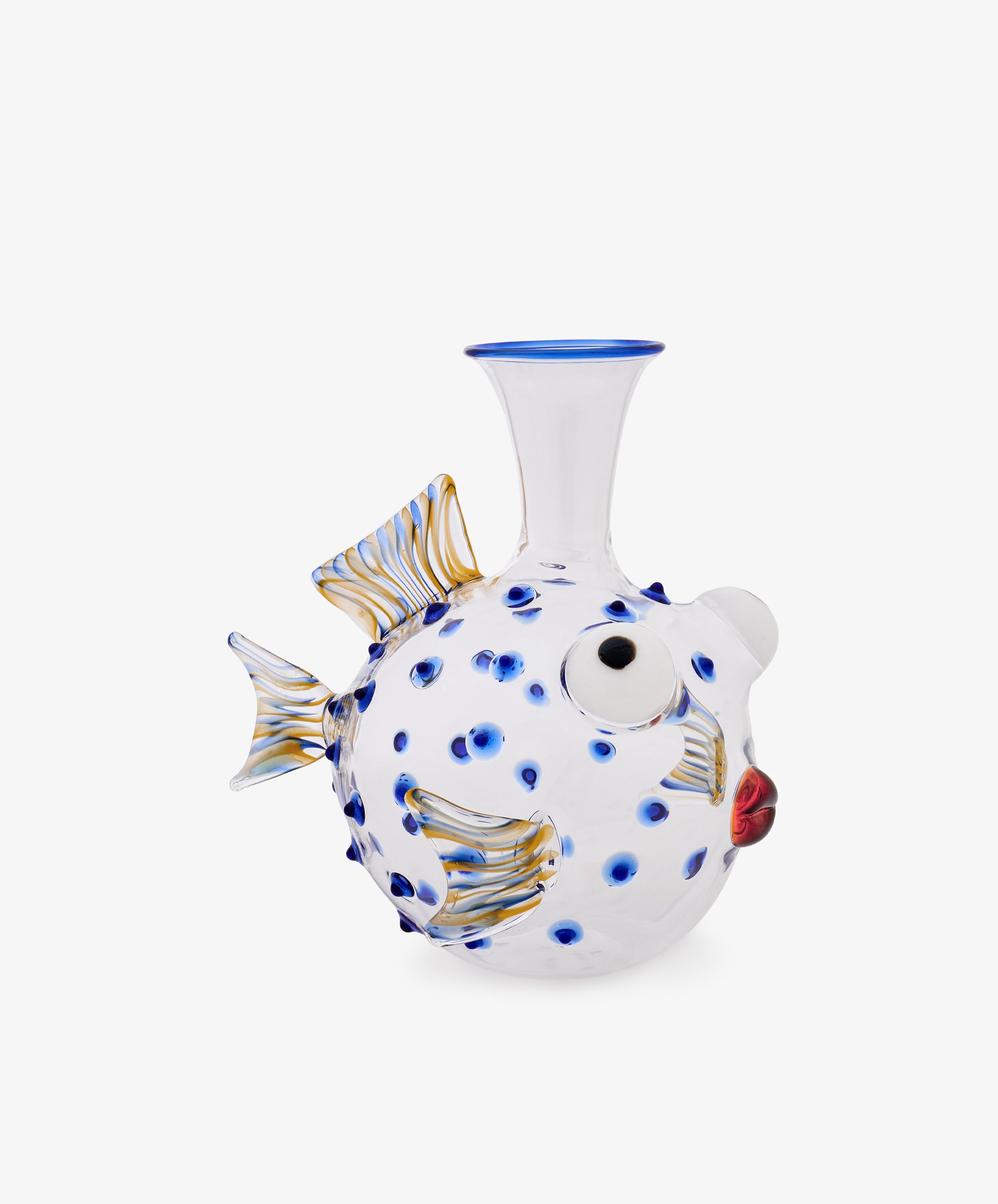 The Pappagallo Decanter, crafted from clear glass in the shape of a pufferfish and adorned with cobalt blue glass spots, gold-accented fins, and red lips reminiscent of whimsical Murano designs, is photographed against a plain white background.