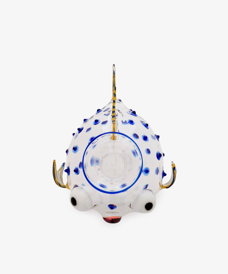 Pappagallo Decanter—a whimsical glass teapot shaped like a fish, featuring cobalt blue glass spots, large eyes, and a gold-colored handle, spout, and fin, viewed from above against a white background; reminiscent of Massimo Lunardon’s playful Murano glass designs.