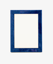 A blank white sheet of paper inside the rectangular, textured Torino Frame finished in deep blue, set against a plain light background, evokes the elegance of geometric marquetry in its subtle patterns.