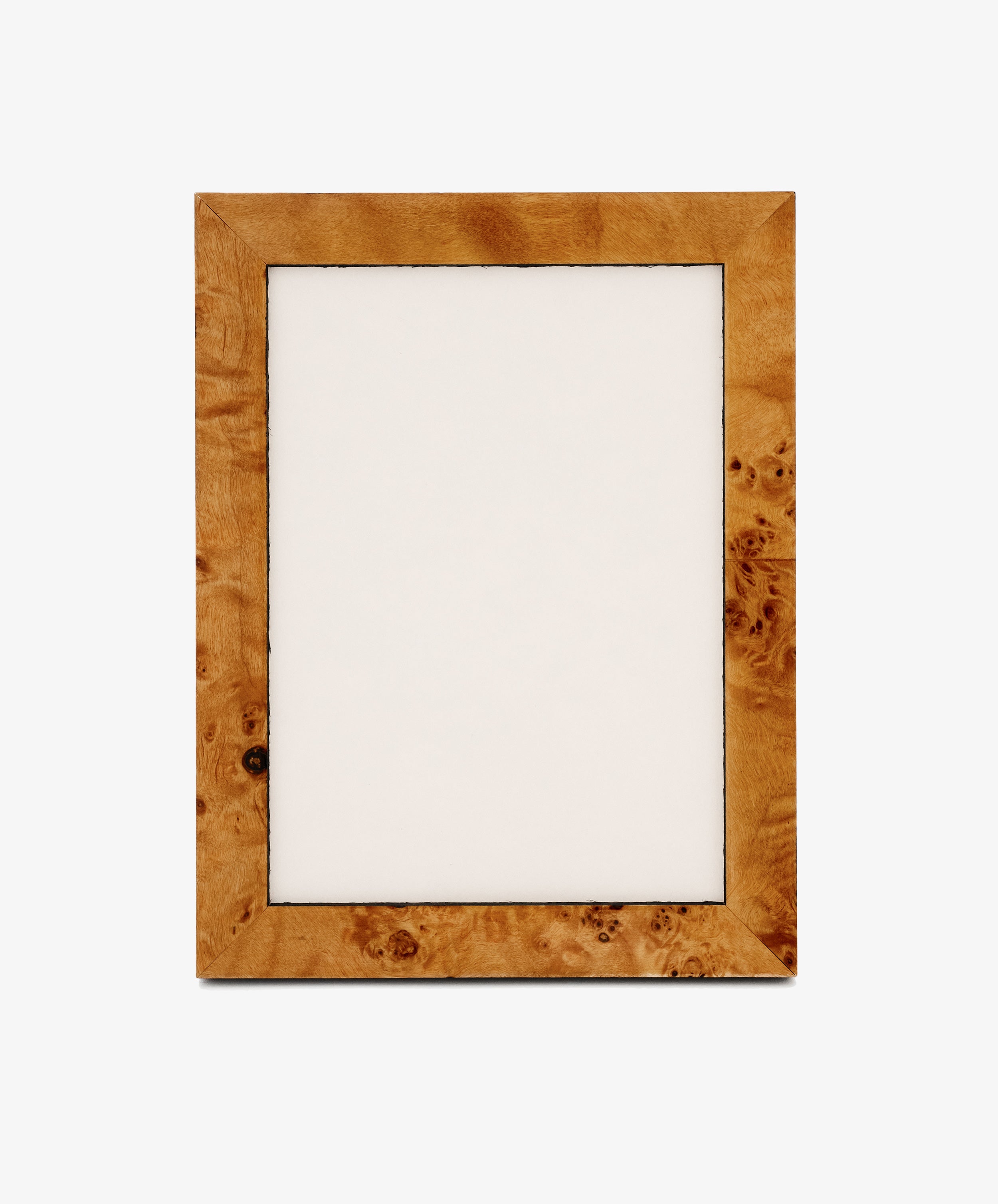 The Torino Frame, a rectangular wooden design with a light brown finish and subtle geometric marquetry details, features an empty white center and stands upright against a plain background.