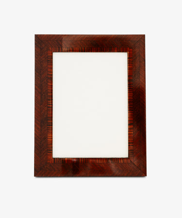 The Torino Frame is a rectangular wooden photo frame featuring a striking herringbone pattern, expertly crafted in the geometric marquetry style, shown empty against a plain white background.