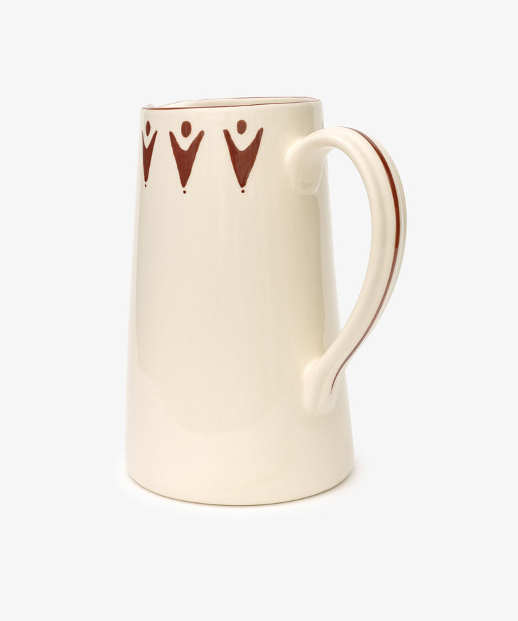 The Vito Jug is a cream-colored ceramic mug with a large handle and brown geometric rim patterns, evoking a handmade look—an ideal unique gift—displayed against a plain white background.